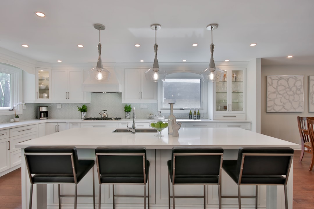 A bright and modern kitchen with a central island and neutral-colored cabinets, showcasing a high-value renovation that appeals to potential home buyers.