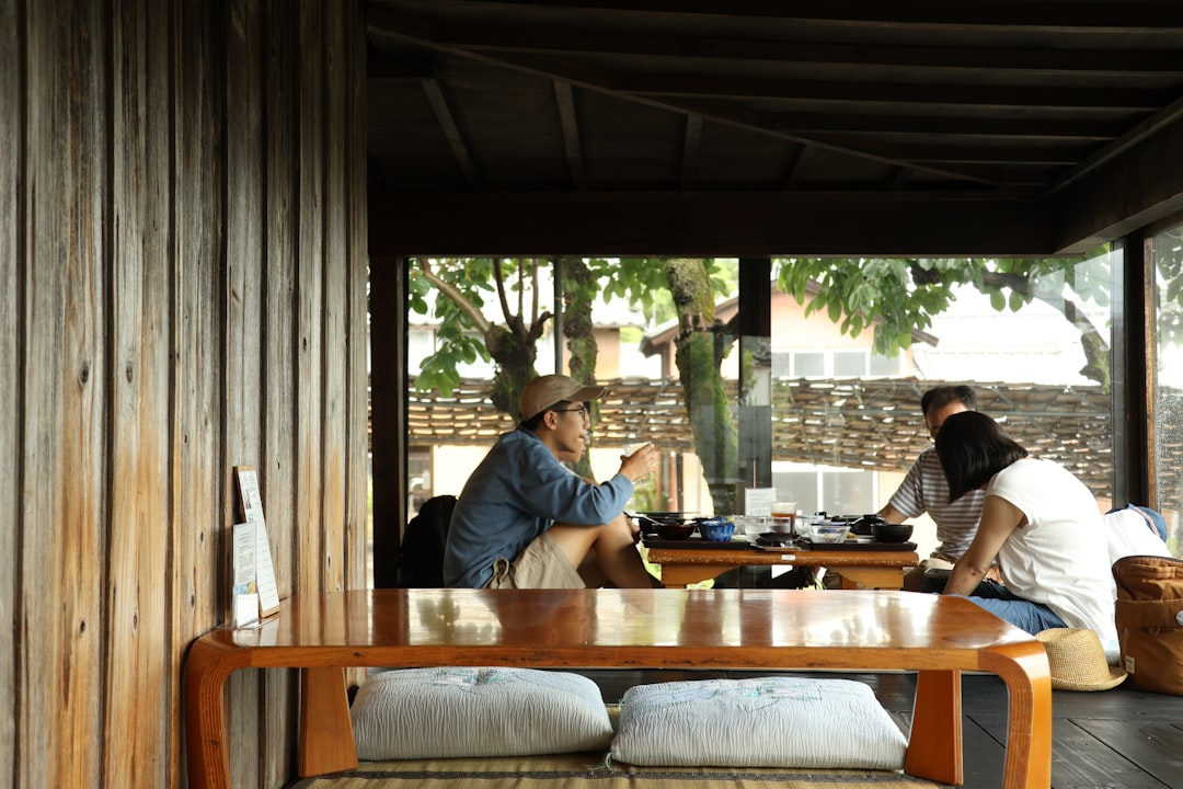 A couple sits together at a sunlit kitchen table, collaboratively reviewing documents and making a plan, representing the process of negotiating after a low appraisal.