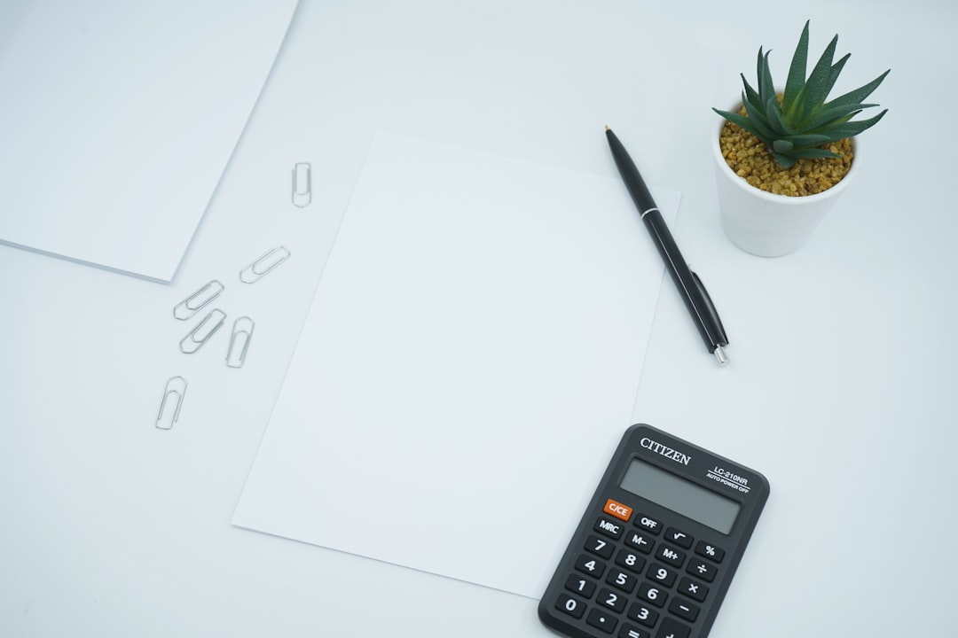 A minimal flat lay of house keys and a calculator on a clean, bright desk, symbolizing the crucial step of calculating the right list price for a Columbus home to maximize profit.