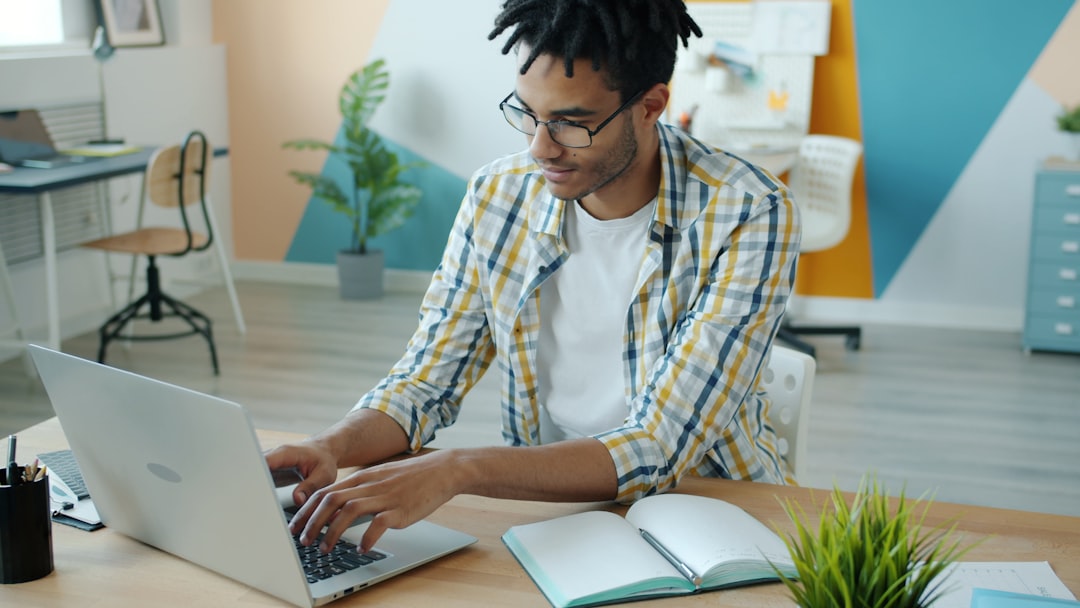 A person efficiently using a laptop in a bright, modern home, illustrating the smart, tech-forward alternative to high-commission real estate agents.