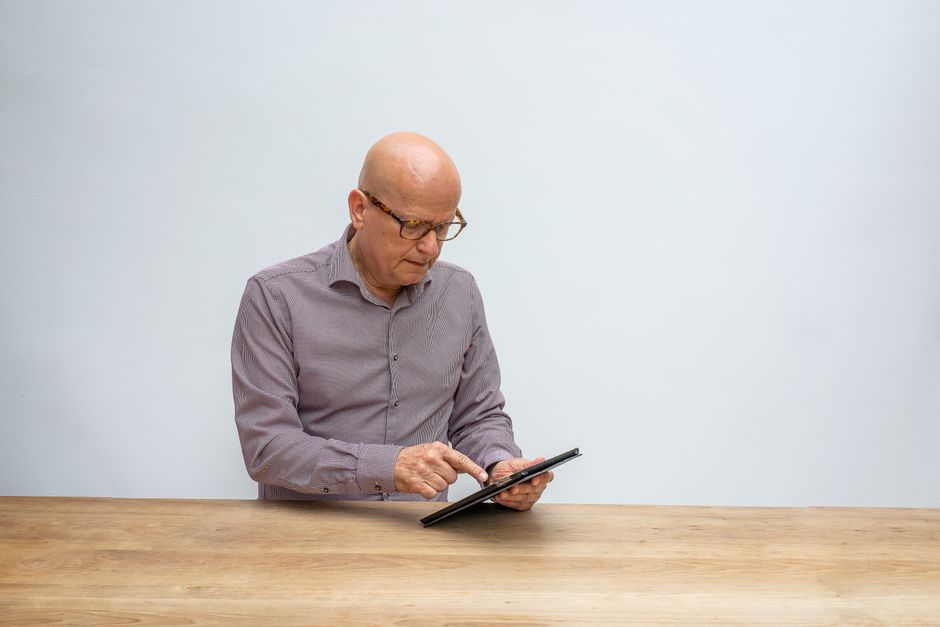 Modern real estate analyst stands in a bright, contemporary kitchen, using a tablet to review market data for a home sale.
