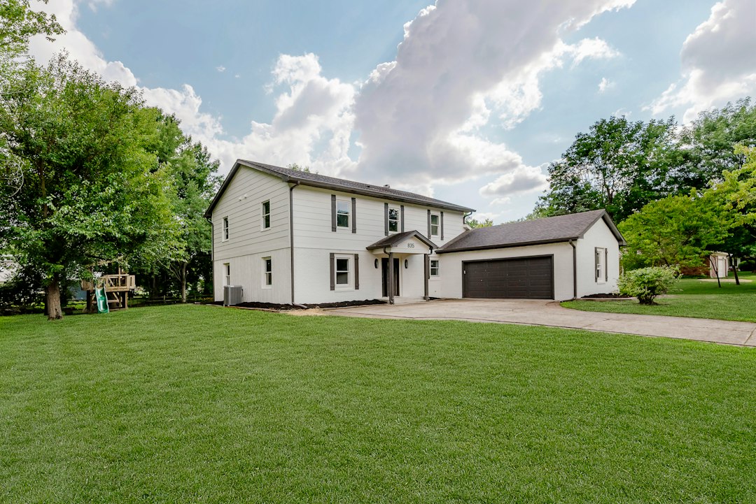The beautiful exterior of a modern suburban family home with a green lawn, representing the ideal 'move-up' property on a bright, sunny day.