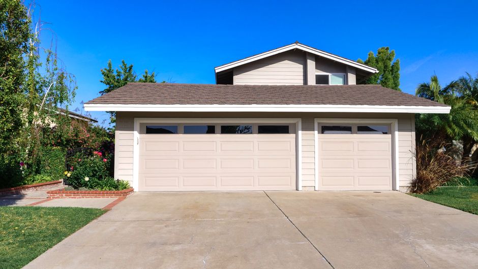 The bright, sunny exterior of a beautiful modern suburban home with great curb appeal, representing a desirable property on the market.