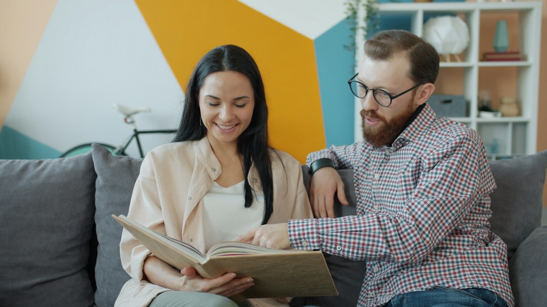 A happy, confident couple smiles as they sign real estate documents, feeling secure about their smart financial decision and protecting their equity.