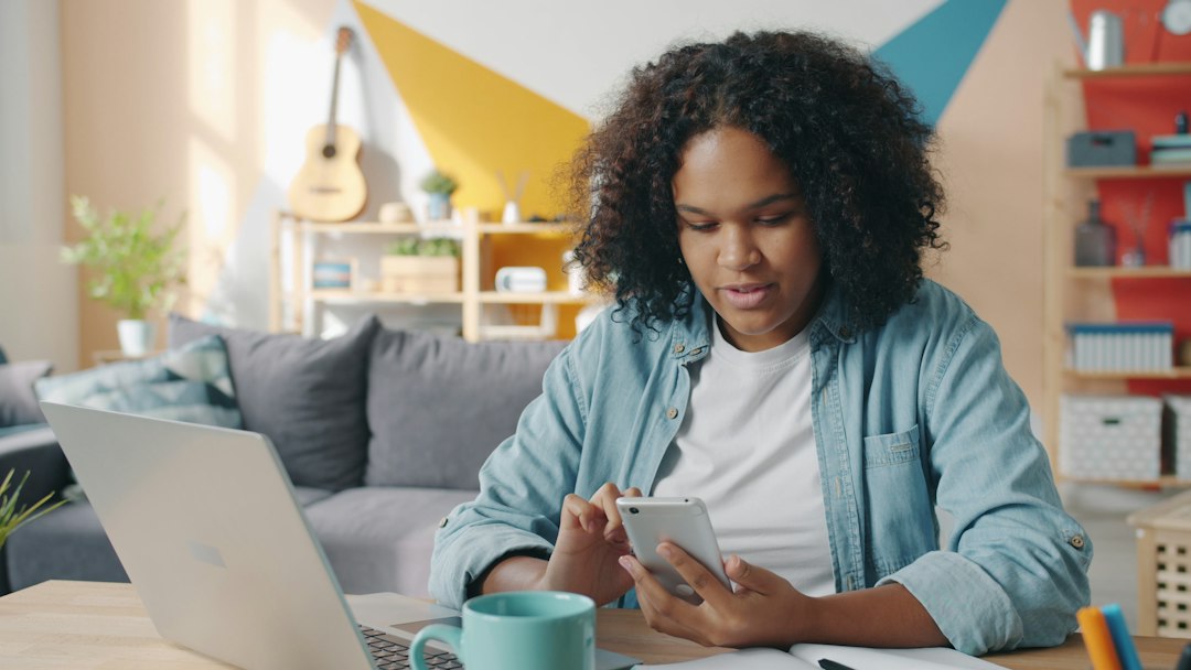 Homeowner sits at a kitchen table with a calculator, house keys, and papers, looking concerned about their finances and th...