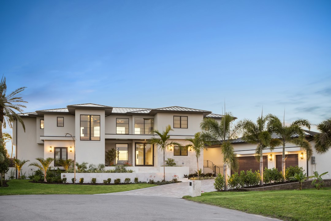 A crisp, professional 'Sold' sign stands on the manicured lawn of a modern suburban home, representing a successful and streamlined real estate transaction.