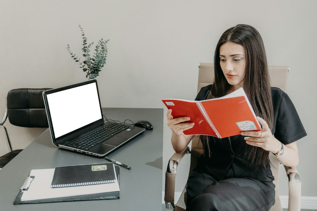 A homeowner sits at a clean, modern desk reviewing financial documents with a calculator, illustrating the smart decision-making involved in a home sale.