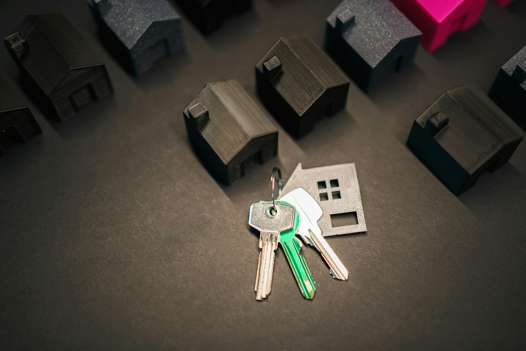 A person's hand holding a set of house keys in front of the blurred background of a welcoming home, symbolizing a successful Columbus home sale.