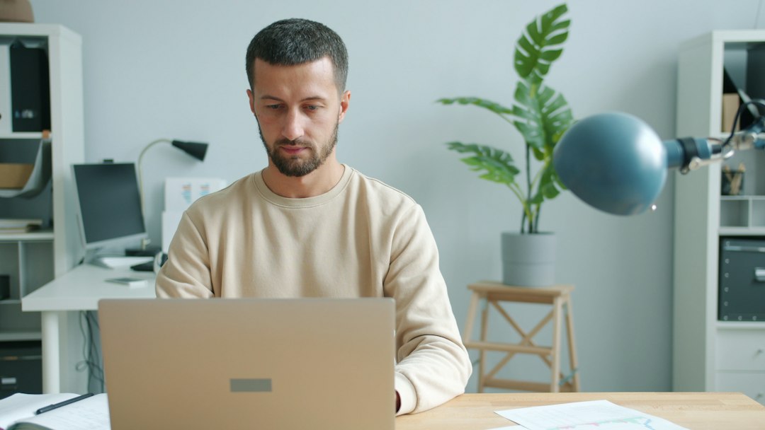 Real estate professional in a modern office analyzing housing market data on a laptop, symbolizing a data-driven digital s...